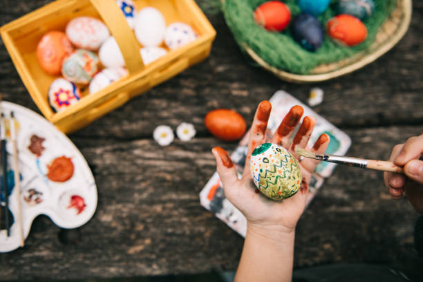 istock little girl painting easter egg with water colors 1299604408
