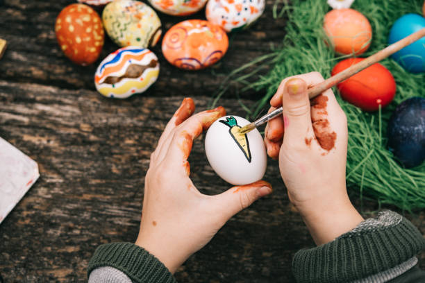 istock little girl holding painting carrot on easter egg 1299604632