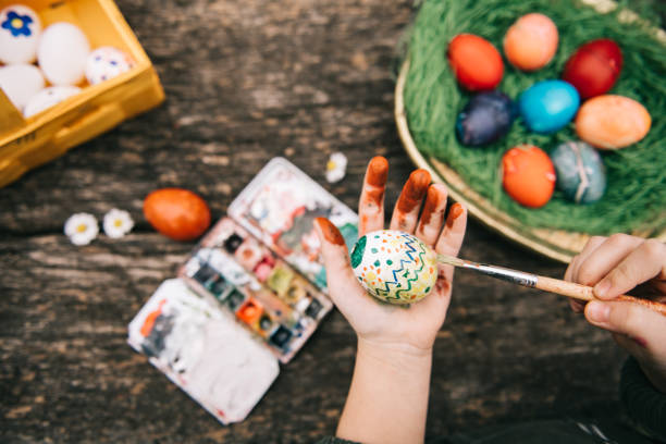 istock little girl painting easter egg with colorful pattern 1299604744