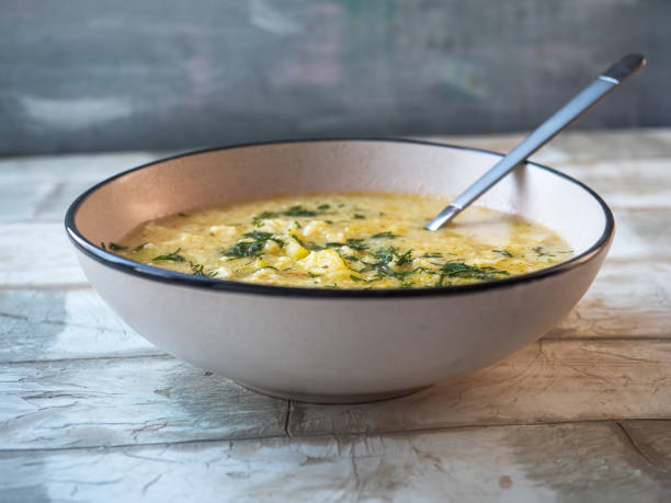 istock Lunch with soup with dumplings and dill in a light ceramic plate on a light table 1299605089