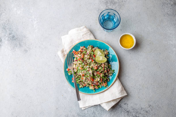 quinoa quinua salat mit tomaten und kräutern in weißer schüssel - tabbouleh vegeterian food middle stock-fotos und bilder