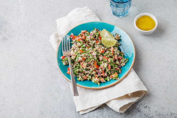 quinoa quinua salat mit tomaten und kräutern in weißer schüssel - tabbouleh vegeterian food middle stock-fotos und bilder