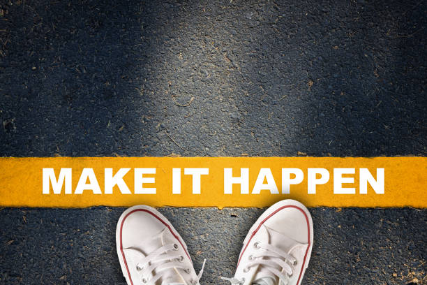 istock Make it happen words with yellow line on asphalt road 1299607368