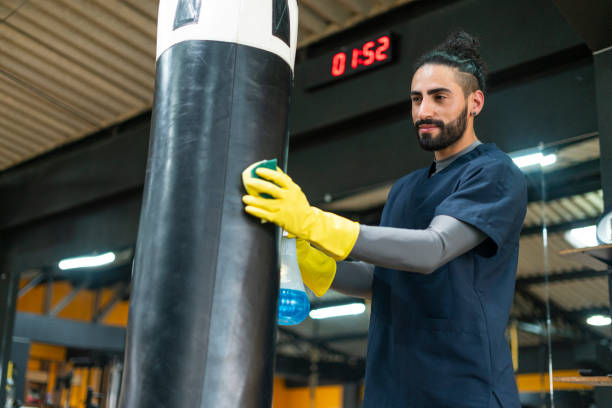 istock Man is disinfecting gym equipment 1299608202
