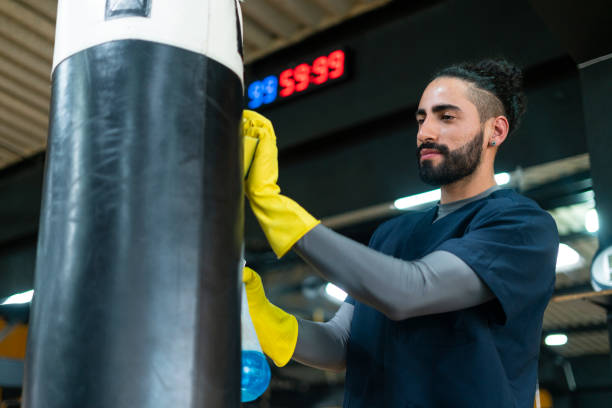 istock Man is disinfecting gym equipment 1299608809