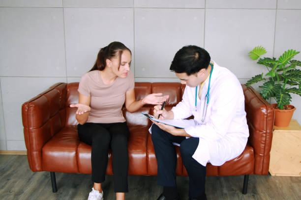 l’homme asiatique de psychiatre conseille et écrit sur le papier pour la femme caucasienne ont des problèmes de santé mentale dans la vie clinique de dépression. patients majeurs de désordre dépressif et concept de soins de santé. - major photos et images de collection