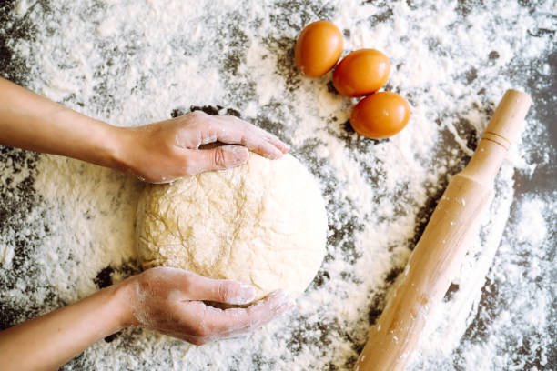 female chef kneading dough on kitchen table.  easter baking preparation. cookies for christmas. - baking flour ingredient animal egg imagens e fotografias de stock