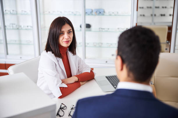 istock Optician receiving a male client in her office 1299613086