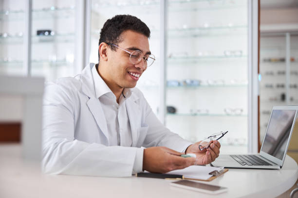 istock Smiling young optician looking at the contacts and glasses 1299613100