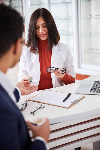istock Optician offering lenses and trendy spectacles to a purchaser 1299613113