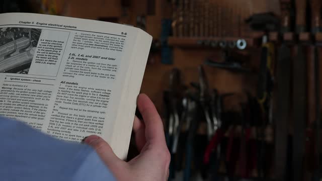 Mechanic Reads Instruction Manual Before Repairing Vehicle