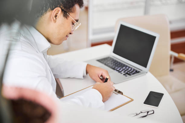 istock Experienced optometrist focused on writing an eyeglass prescription 1299614849