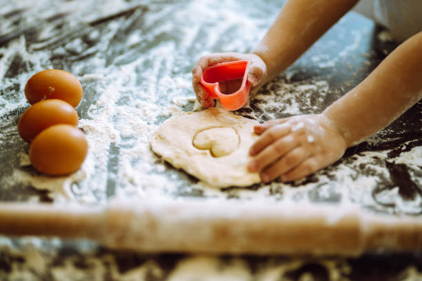 istock Easter baking preparation. A little chef carves ginger Cookies. 1299615594