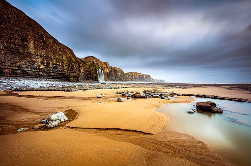 Rocky coastline and waterfall near Southerndown, Wales