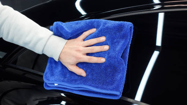 istock A man wipes a car with a rag 1299619564