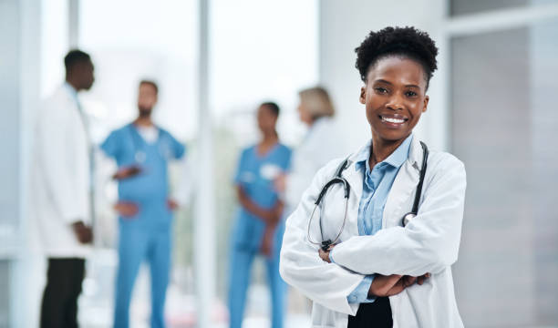 It's my mission to guide you towards better health Portrait of a young doctor standing in a hospital female doctor stock pictures, royalty-free photos & images