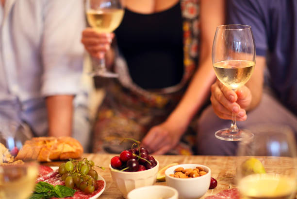istock Hands of a group of people cheering with white wine 1299620390