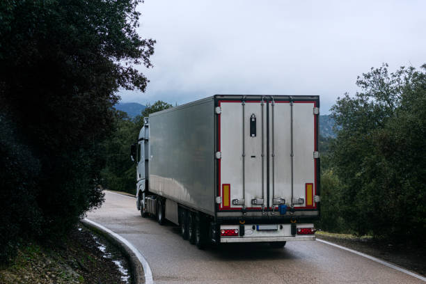 istock Refrigerator truck turning a curve on a narrow 1299620778