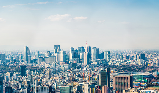 Aerial panorama over the crowded cityscape of central Tokyo towards the skyscrapers of Shinjuku, Japan.