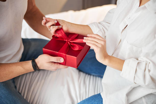 istock Woman unwrapping a gift given by her husband 1299626717
