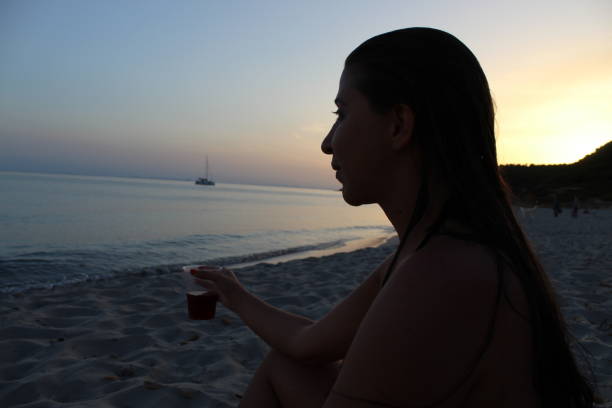 istock Woman in the beach at sunset 1299627902