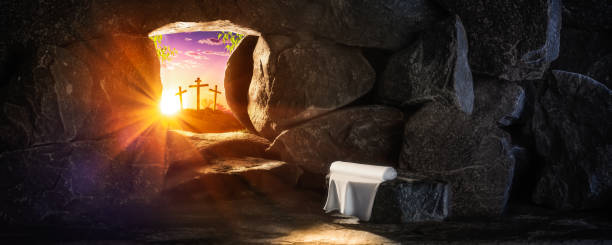 Crucifixion And Resurrection Concept Empty Tomb With Linen Cloth At Sunrise With Sunlight Shining Through 
The Open Door And Three Crosses In The Distance 
- Crucifixion And Resurrection Concept tomb photos stock pictures, royalty-free photos & images