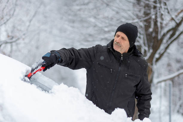 istock Senior man scraping snow from car 1299630487
