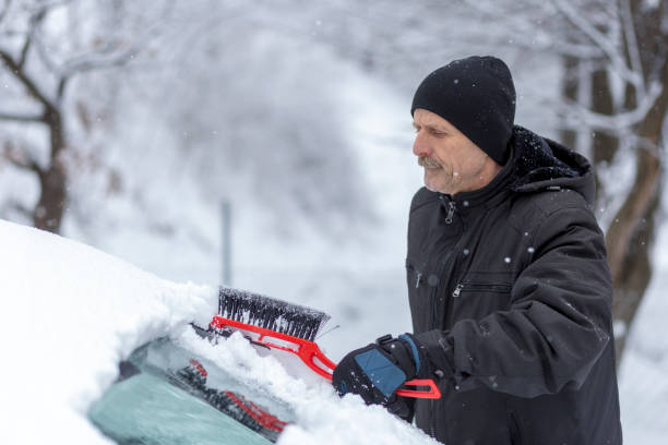 istock Concerned man removing snow from his car 1299630597