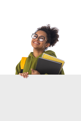 Friendly ethnic black female high school student in eyeglasses with banner and composition book isolated on white background