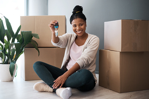 Portrait of a young woman holding the keys to her new home