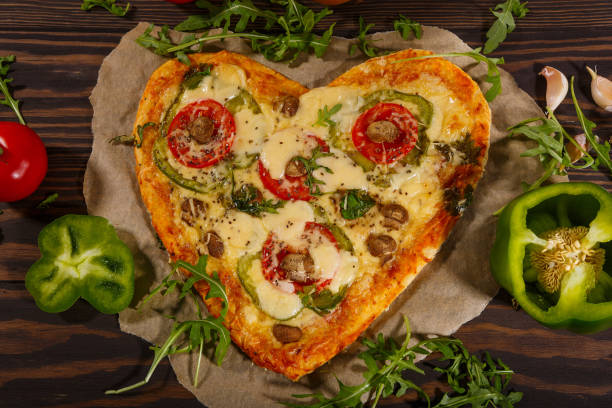 istock Pizza in the shape of a heart  and fresh vegetables 1299633076