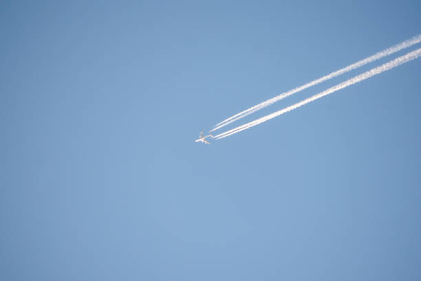 istock White plane flying in the blue sky. 1299633374