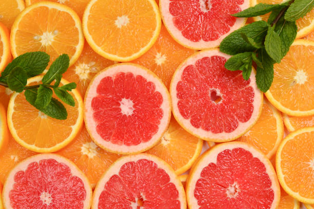 istock Slices of oranges and a grapefruits and mint as a background. 1299633444