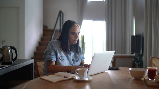 istock Transgender woman using laptop working from home 1299634521