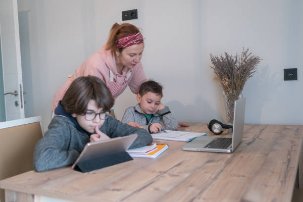 istock Mom helping kids with homework in the kitchen At Desk In kitchen. 1299637323