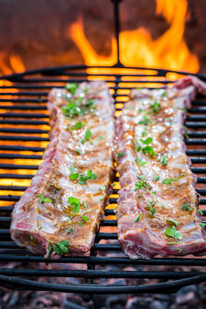 istock Raw ribs with spices on grill with fire 1299637683