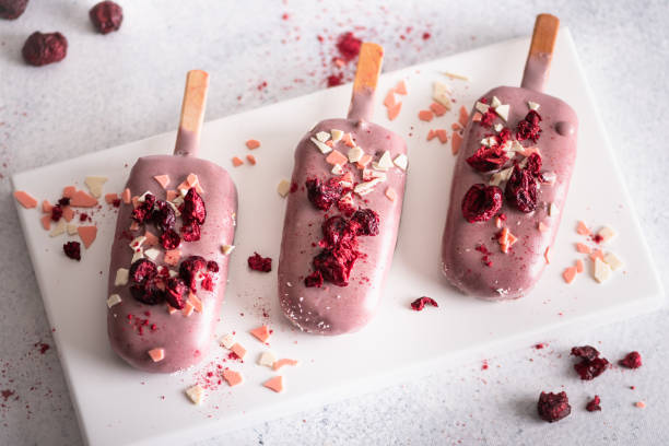 Ice cream sticks with white chocolate, fruit and colored sugar on a white background.