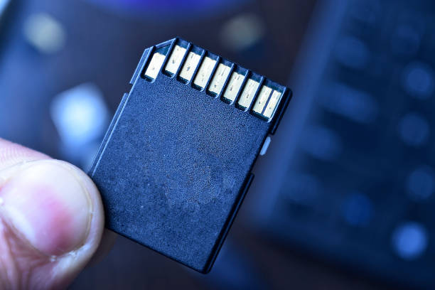 istock Camera sd card in hand, closeup of memory card 1299644016