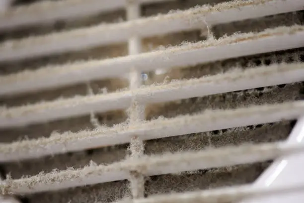 Photo of Dirty air ventilation grill of HVAC with clogged filter.