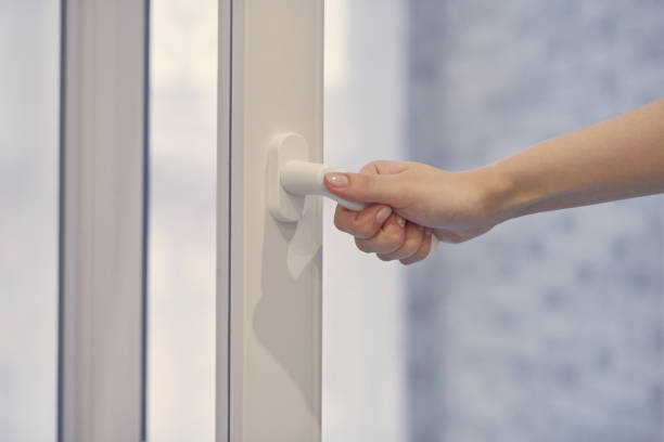 istock Female hand opens and closes plastic window. Close up. 1299646288