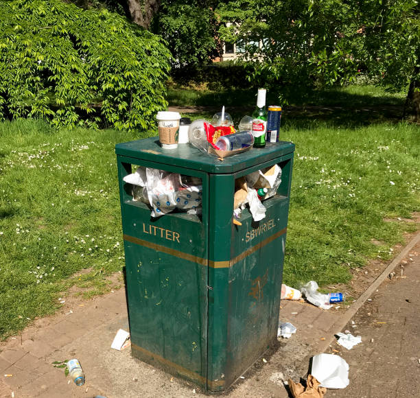 Cardiff, Wales  - May 2018: Overflowing litter bin in a public park in Cardiff city centre