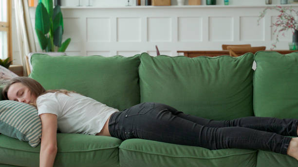 istock Exhausted or bored sleepy woman falls down on sofa 1299648960