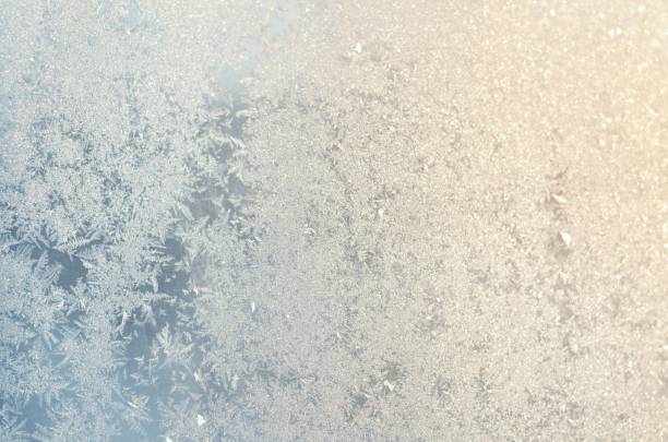 istock Light blue frosty patterns on the glass 1299649777