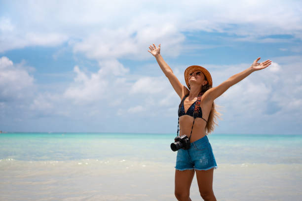 istock Woman with open arms enjoying the tropical beach 1299651025