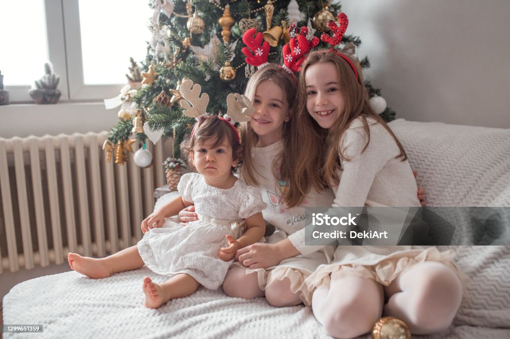 Tres Hermanas Con Vestidos Blancos Abrazando Bajo El Árbol De Navidad Foto de stock y más banco de imágenes de Abrazar - iStock Tres Hermanas Con Vestidos Blancos Abrazando Bajo El Árbol De Navidad Foto de stock y más banco de imágenes de Abrazar - iStock