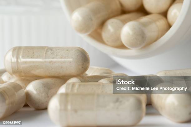 Probiotic Capsule Spilled From A Bottle Stock Photo - Download Image Now - Probiotic, Abdomen, Healthcare And Medicine