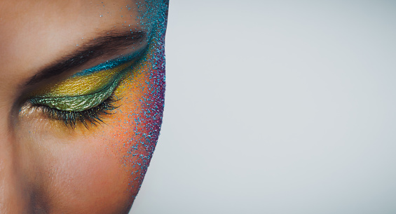 Closeup Photo of a Face Part of a Beautiful Girl Over Clean Background. Young Woman with Festive Colorful Makeup. Photo with Copy Space.