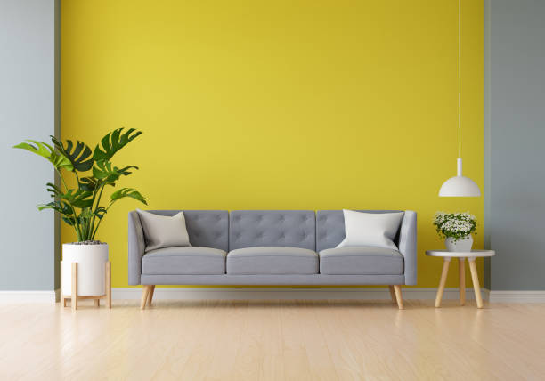 istock Gray sofa in yellow living room with free space for mockup, 3D rendering 1299653639