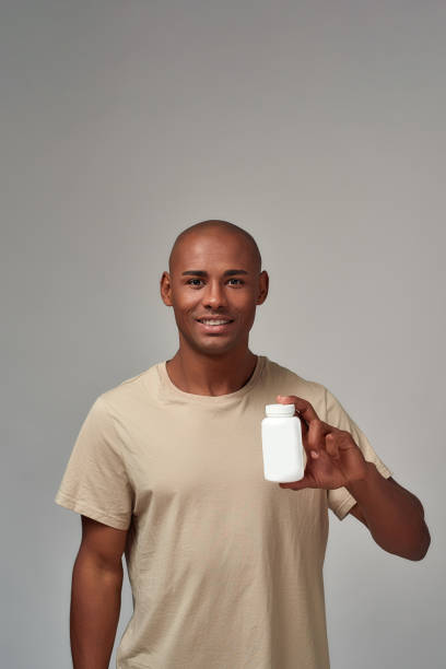 istock Man presenting a white medicine bottle with a smile 1299655006