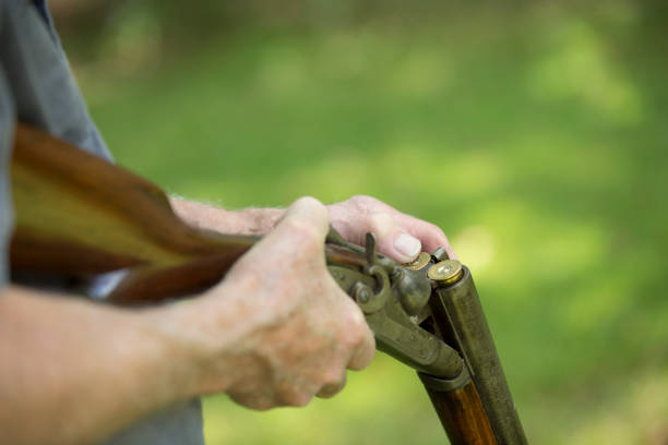 istock Man loading an antique 12 gauge double barrel shot gun. 1299655277